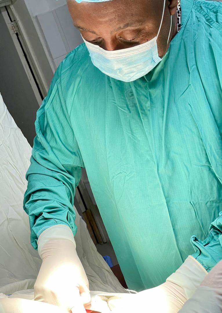 Dr Garry René en tenue chirurgicale au bloc opératoire, trois décennies de pratique